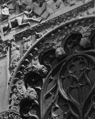 Westfacade, middenportaal, detail: linker zwik onder de latei van het portaal