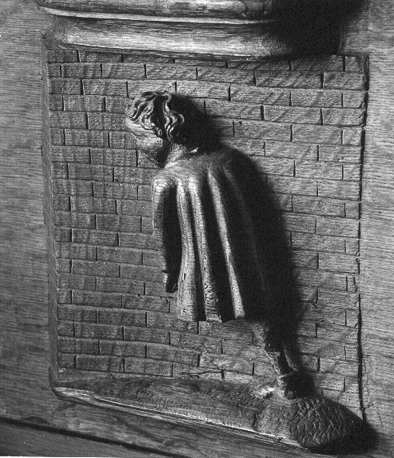 Koorbanken, detail: misericorde met de uitdrukking "Men kan met het hoofd geen muren breken"