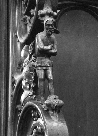 Koorbanken, zuidzijde:voluutdetail met een wat gebogen staande mannenfiguur