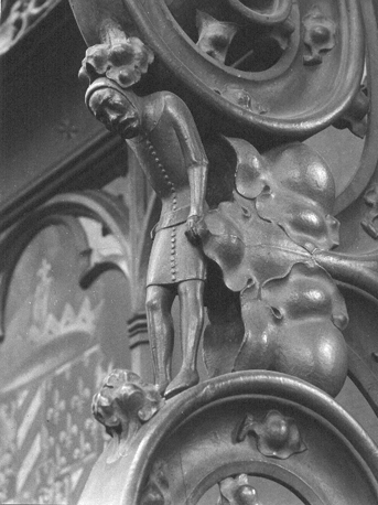 Koorbanken, noordzijde: voluutdetail met een wat gebogen staande mannenfiguur