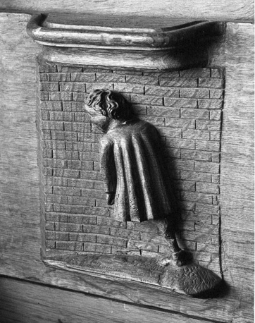 Koorbanken, detail: misericorde met de uitdrukking "Men kan met het hoofd geen muren breken"