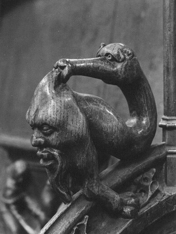 Koorbanken, detail: knop met fantasiedier
