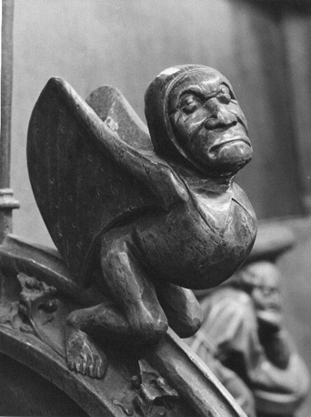 Koorbanken, detail: knop van een menselijk wezen met vleugels