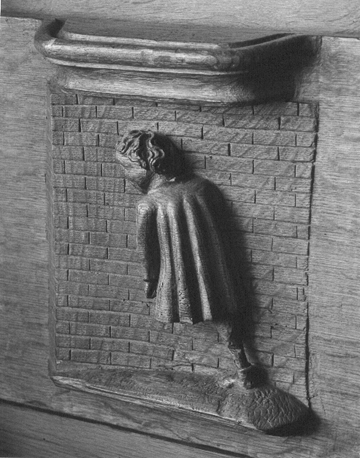 Koorbanken, detail: misericorde met de uitdrukking "Men kan met het hoofd geen muren breken"