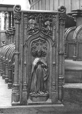 Koorbanken, detail van noordzijde: architectuurdecoratie, engelen, heilige Barbara