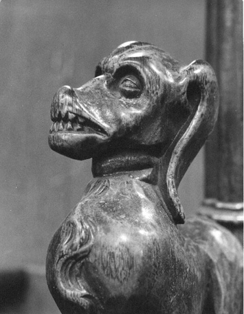 Koorbanken, detail: bovengedeelte van knop met een hond