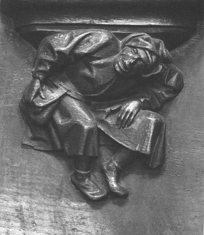 Koorbanken, detail: misericorde met een in elkaar gedoken man