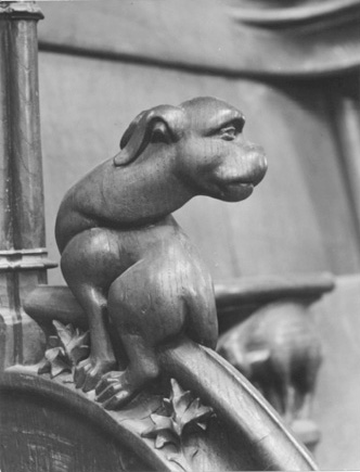 Koorbanken, detail: knop met een hond die zijn kop naar achteren wendt