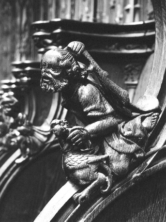 Koorbanken, detail: knop met een man die een vogel wil slaan met een knuppel