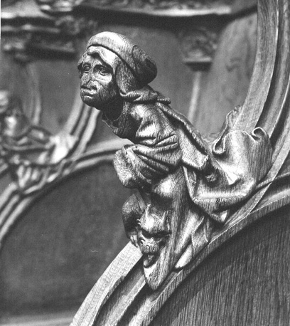 Koorbanken, detail: knop met een zittende man die een draakje aan zijn voeten heeft