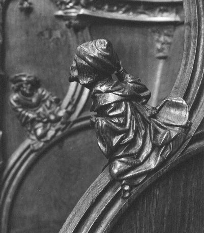Koorbanken, detail: knop met een zittende man