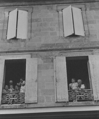 Kinderen en grootouders uit hun balkons hangend
