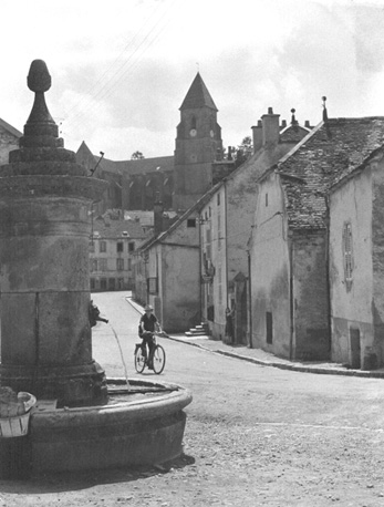 Straatscène in Saint Seine l'Abbay met kerk op de achtergrond