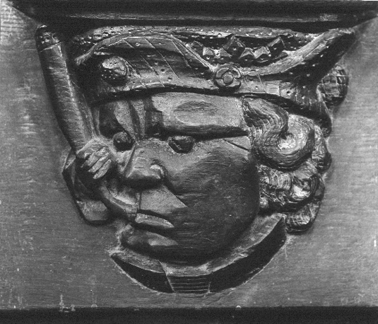 Detail koorgestoelte; Misericorde: hoofd met hoorn of pijp