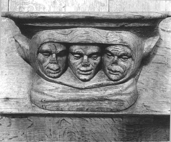 Detail koorbanken; misericorde van drie hoofden met een hoofddeksel met oren