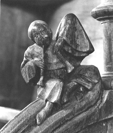 Koorgestoelte, detail: Zittend menselijk figuur met twee fluiten (of trompetten ?)