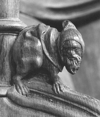 Koorgestoelte, detail: Zittend figuur met dierlijk lichaam en menselijke kop met baard