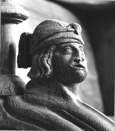 Koorgestoelte, detail: Menselijk hoofd met hoofddoek