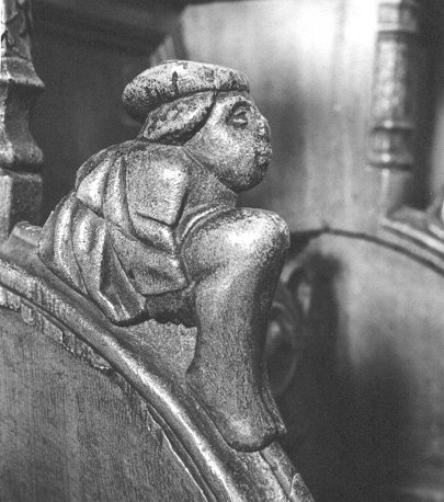 Koorbank: armleuning gedecoreerd met menselijke figuur