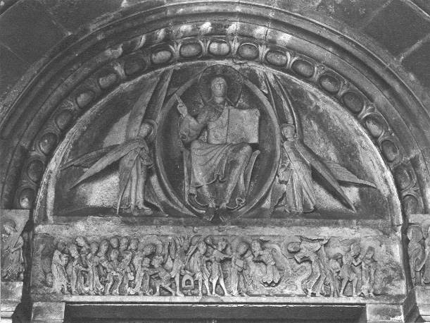 Timpaan: Tronende Christus, een spreek-gebaar makend en met boek in de hand, aan weerszijden twee engelen met zes vleugels; latei: scènes uit de Passie