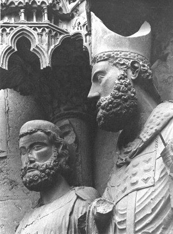 Noordfacade, middenportaal, linker portaalwang, sint Remigius groep, detail: hoofden van Chlodovech (li.) en Remigius (re.)