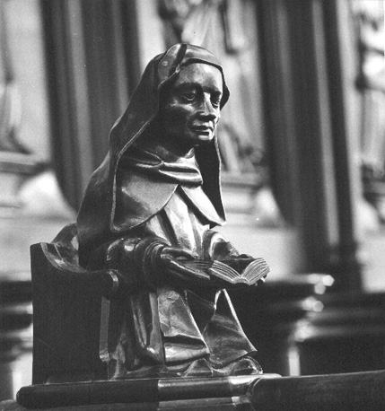 Koorbanken, dekstuk: lezende zittende figuur
