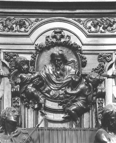 Biechtstoel, detail: beeldsnijwerk boven standbeelden: God de Vader en twee putti