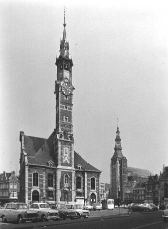 Zicht op zijgevel van stadhuis met belfort en de Sint-Trudokerk (rechts)