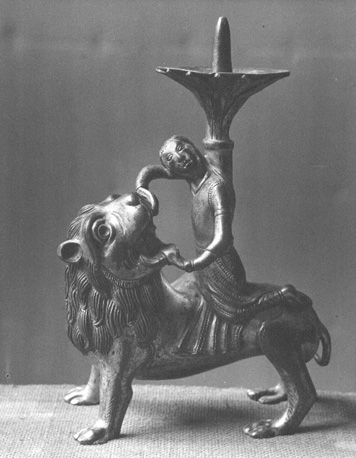 Romaanse kandelaar: man op de rug van een leeuw (Samson doodt de leeuw met zijn blote handen)