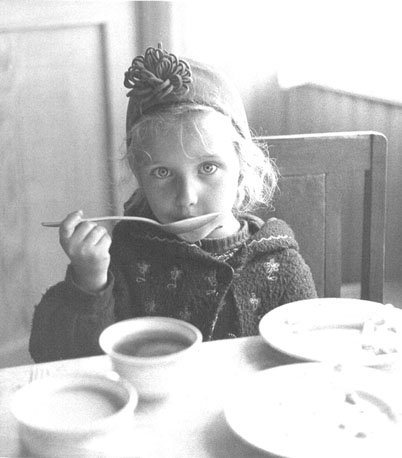 Klein meisje (met lepel) in crèche
