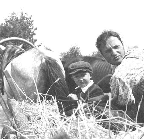 Boeren (vrouw en kind) op een boerenkar