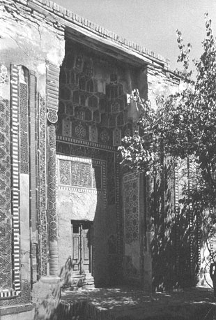 Ingang, gewelfde poort met oude houtgesneden deur