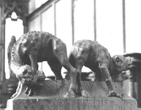 Koorgestoelte, bovenop afsluitende wang: twee monsters, misvormde dieren