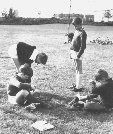 Jongens met voetbalschoenen, op een grasveld