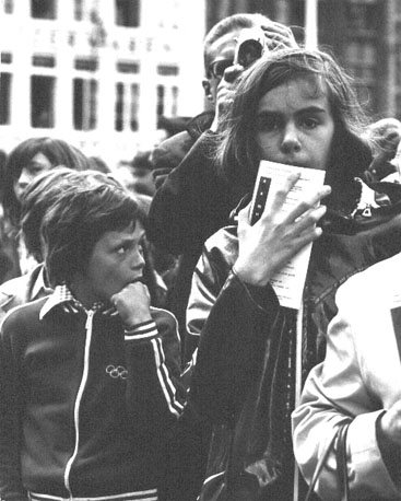 Kinderen op straat, man met camera op de achtergrond
