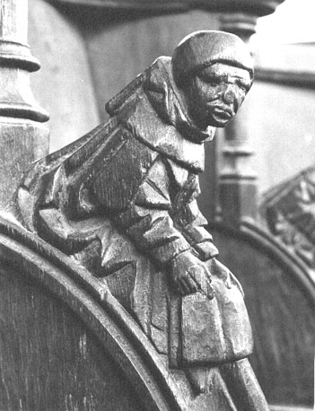 Koorbank, detail: zittend figuur met boek in zijn handen