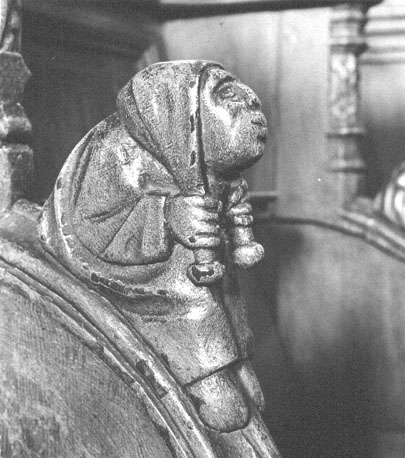 Koorbank: armleuning gedecoreerd met menselijke figuur