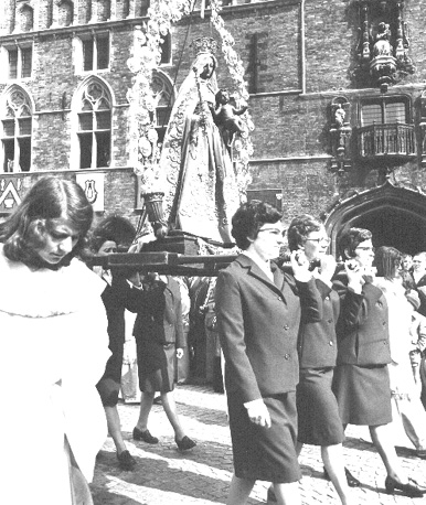 Beeld van de Maagd Maria met Christuskind rondgedragen in een stad (waarschijnlijk christelijke feestdag: Maria Hemelvaart)