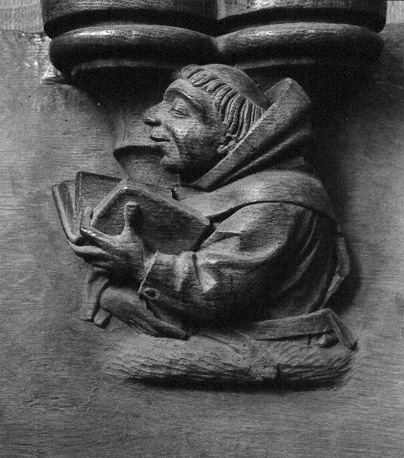 Koorgestoelte, misericorde: monnik met geopend boek in linkerhand, lezend of zingend