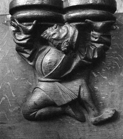 Koorgestoelte, misericorde: man steunend op een knie die iets boven zich onder-steunt (de misericorde); of: dansend figuur (Koning David als danser ?)