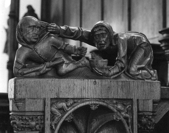 Koorgestoelte, bovenop afsluitende wang: twee figuren, vechtend (?)