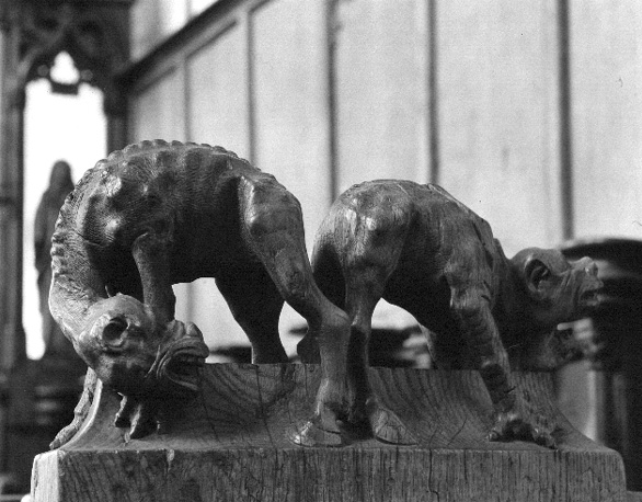 Koorgestoelte, bovenop afsluitende wang: twee monsters, misvormde dieren