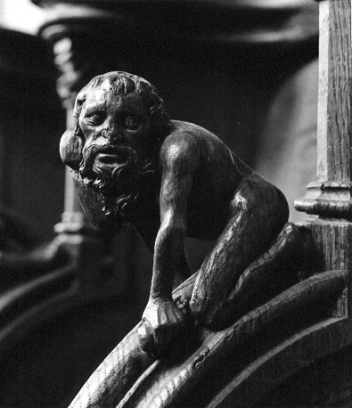 Koorbanken: mannelijk figuur met baard op armleuning