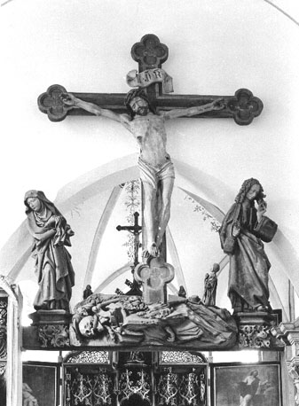 Boven ingang van het koor: Triomfkruis, gekruisigde Christus, met Maria en Johannes aan weerszijden van het kruis; gebeente van Adam aan de voet van kruis, figuurtje van de stichter