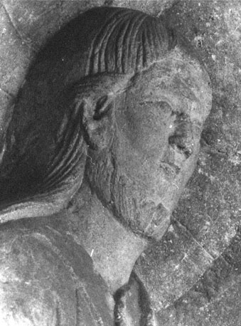 Timpaan: Tronende Christus, een spreek-gebaar makend en met boek in de hand, aan weerszijden twee engelen met zes vleugels, detail: hoofd van Christus