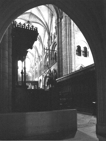 Viering: koorgestoelte met zicht op koor en retrochoir, en (in) noorder transept, vanuit het westen