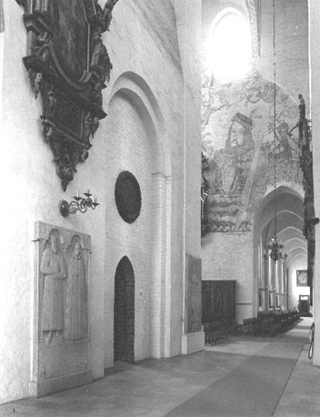 Kooromgang (zuidelijk deel) met zicht op zuidelijke zijbeuk; muurschildering op westelijke muur van zuider transept; verschillende grafstenen