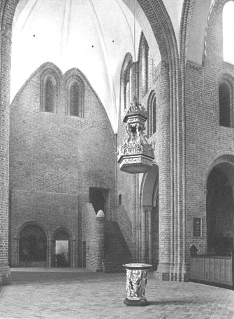 Kerk, viering, zuider transept met stenen trap naar dormitorium; op voorgrond doopvont