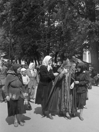 Oude man (monnik) temidden van vrouwen op straat
