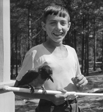 Jongen met vogel op een stok